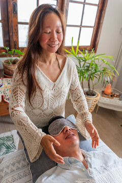 Woman Performs Energy Healing on a Man in a Bright Room