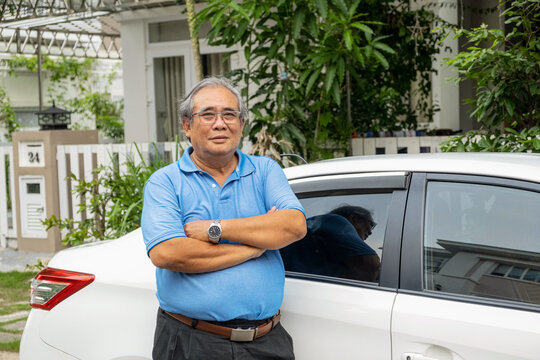 Nice portrait of senior man standing near his old car