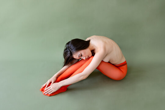 Model in orange tights on green backdrop