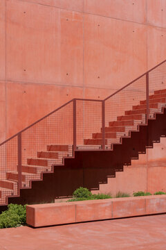 Minimal red concrete stairs with geometric shadows