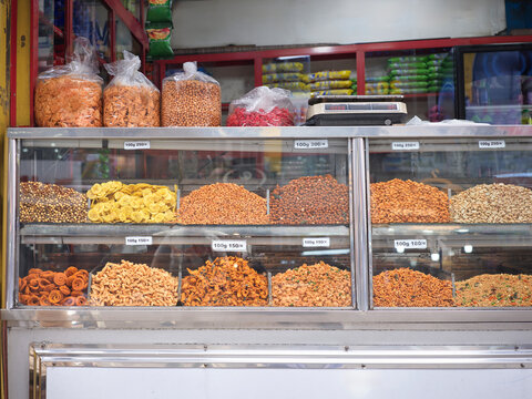 Snack Shop Offers Various Nuts in a Busy Market Area