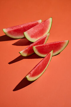 Fresh watermelon slices on a vibrant orange background