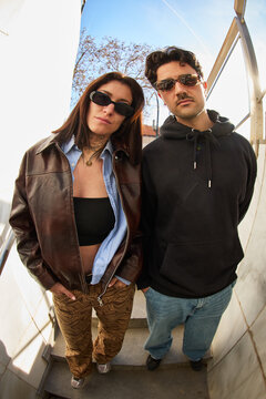 Stylish young adults pose outdoors in casual outfits