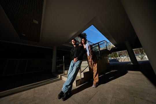 Friends standing by stairs in a public space during the day