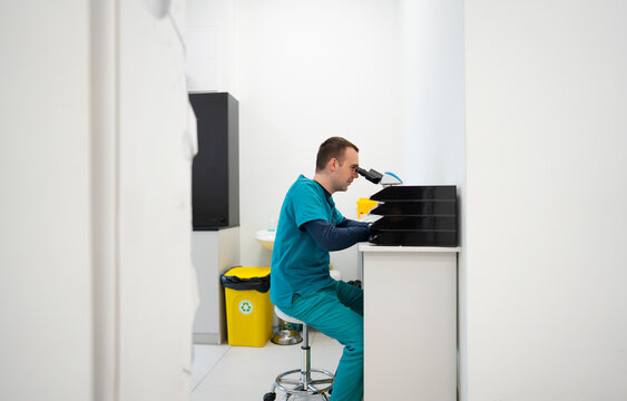 Scientist works with microscope in lab setting