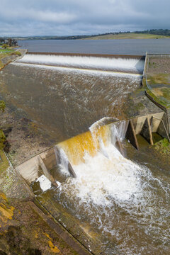 Water rushing over a reservoir spillway and over a manmade waterfall