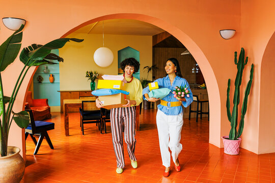 Women carrying packages and flowers at colorful home ugc