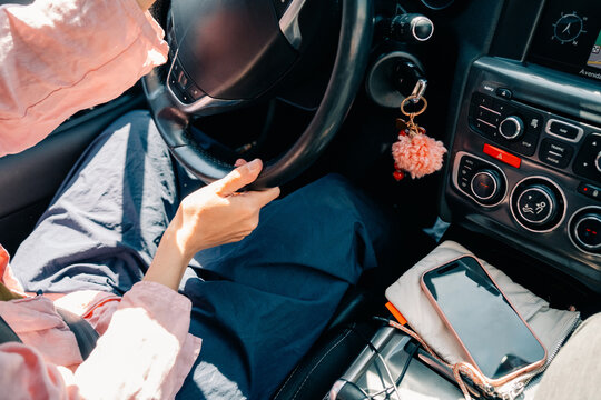 Driver Starting a Car With a Smartphone and Accessories Inside