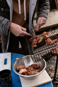 A man puts fried meat into a bowl