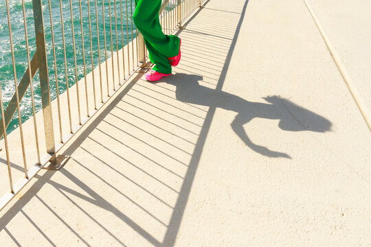 Woman Leans Against Railing by the Sea 