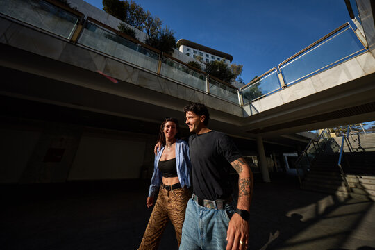 Couple walking together in a modern urban setting during dayligh