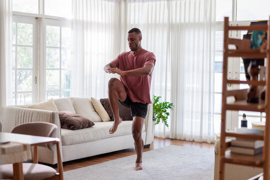 Man exercising in bright living room.