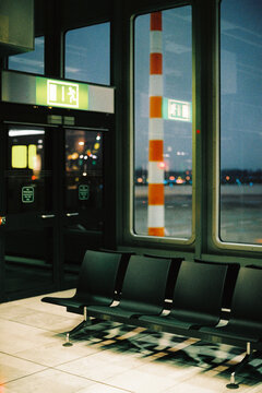 Empty airport waiting area at night with illuminated exit sign