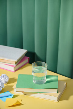 A glass of water on top of books, a scene that evokes calmness