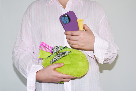 The person is holding a green bag and a purple phone.
