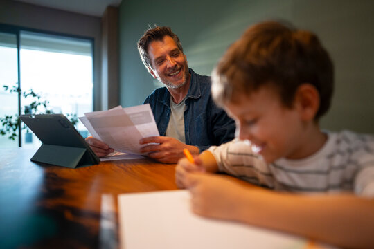 Child drawing while father works in background