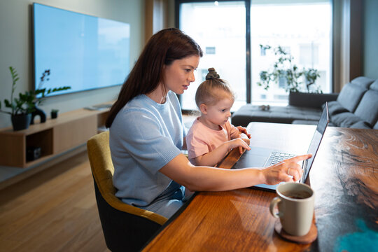 Woman and child using a laptop in a living room