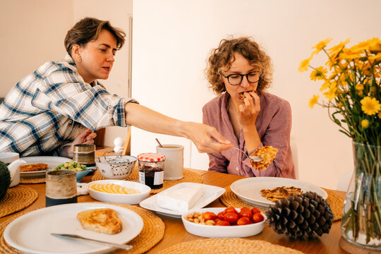 Two Women Share Breakfast at a Table in a Cozy Home Setting