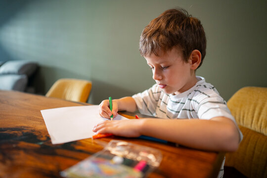 Focused child drawing with colored pencils