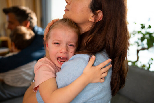 Crying child seeking comfort from mother