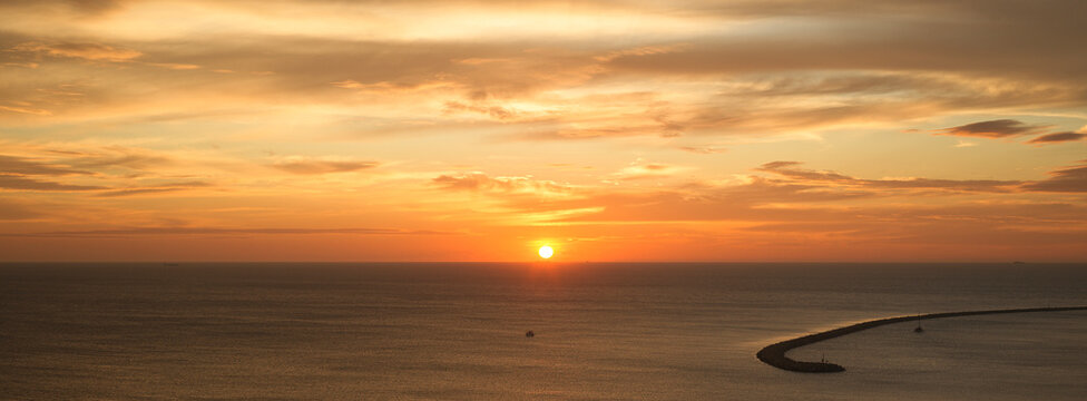 Sunset Over the Indian Ocean With a Distant Pier on the Horizon