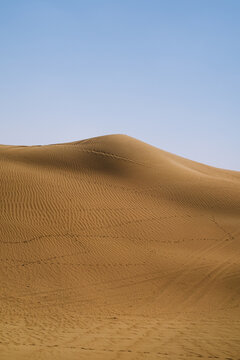 Rippled desert dune with faint tracks