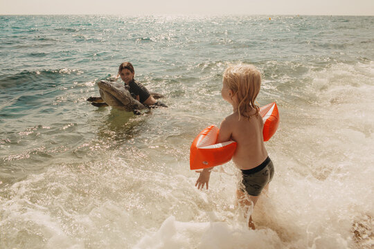 The children are playing in the water with an inflatable crocodile