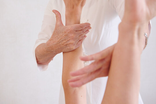 Therapist examining patient arm during treatment