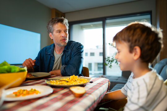 Father Talking With Son At Breakfast