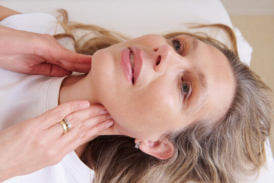 Patient touching neck during self examination
