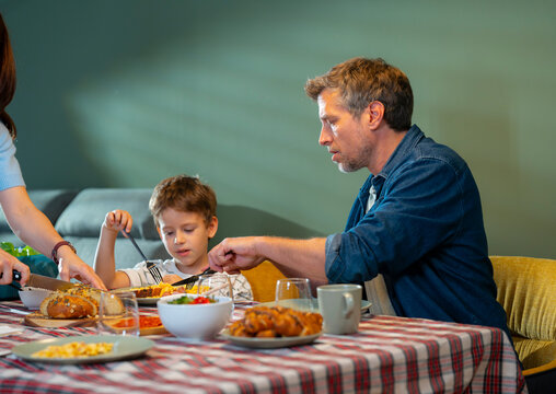 Father and Son Eating Together at Home