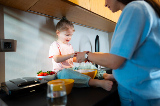 Child assists parent in cooking