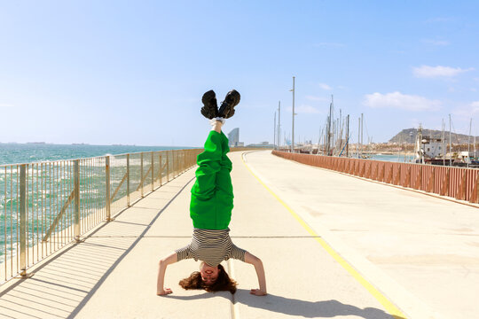Young Person Does Handstand on Walkway