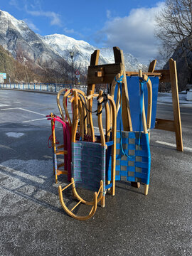 Sleds Lined up on a Street in an Alpine Village Under Bright Skies