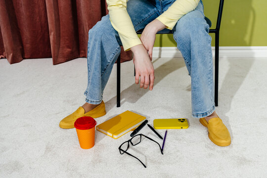 Woman Sitting on Chair with Dropped Personal Items on Floor