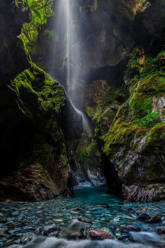 Waterfall in cave with a glacial river vertical