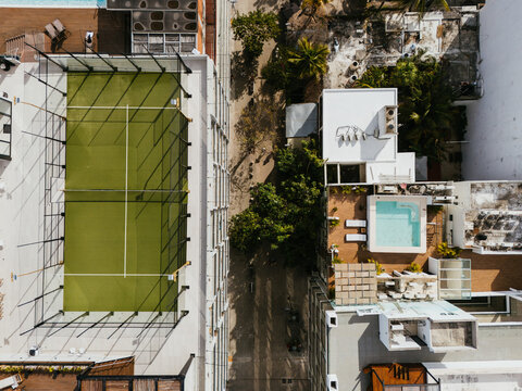 Top view of rooftop tennis court with surrounding buildings
