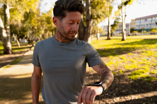 Man Looking at Smartwatch Outdoors