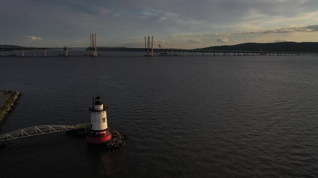 Aerial view of Sleepy Hollow Lighthouse on the Hudson River with the Governor Mario M. Cuomo Bridge in the background at dusk Sleepy Hollow, New York, United States.