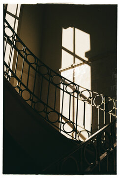 Sunlight and shadows on curved staircase in Porto interior