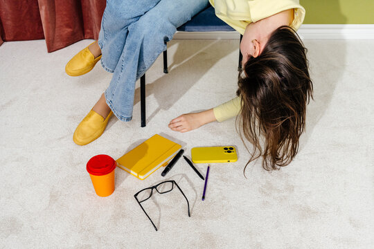 Exhausted Woman Leaning from Chair with Scattered Work Items