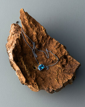 Blue Gem Pendant on Wooden Block Premium Flat Lay