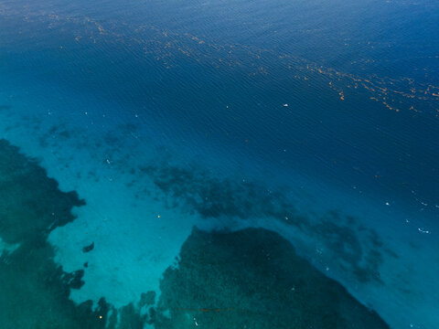 drone view of deep blue ocean with reef formations
