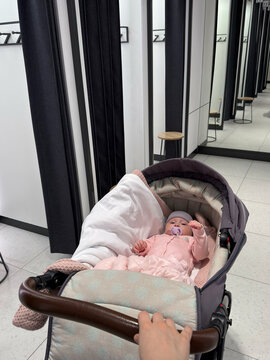 A child in a stroller is seen in a store's fitting room.