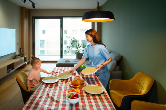 Mom serves food at table in modern home