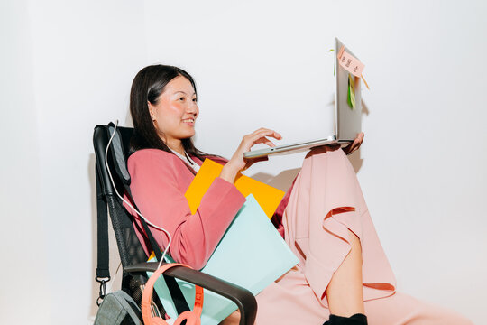 Busy Smiling Woman Working on Laptop With White Background
