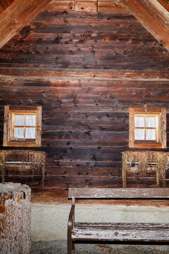 View of a wooden cabin with windows with curtains