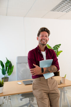 Man Holding Notebook and Smiling at Camera