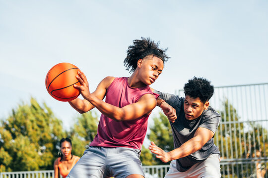 Intense outdoor basketball match between two players