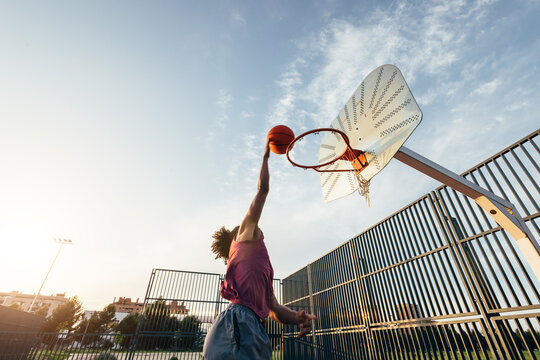 Basketball player dunking on outdoor court